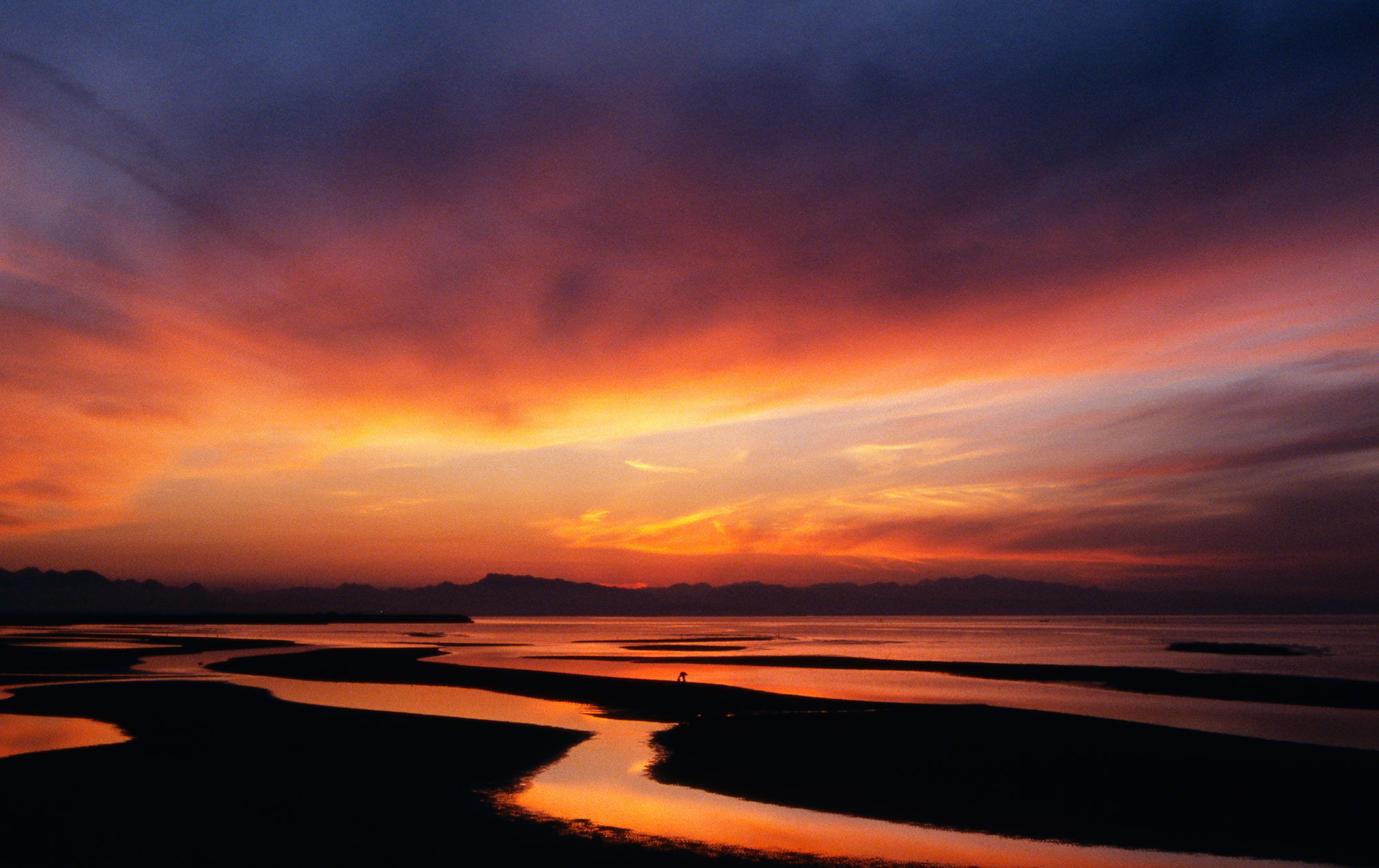 海に落ち干潟に光る壮大な真玉海岸の夕陽。